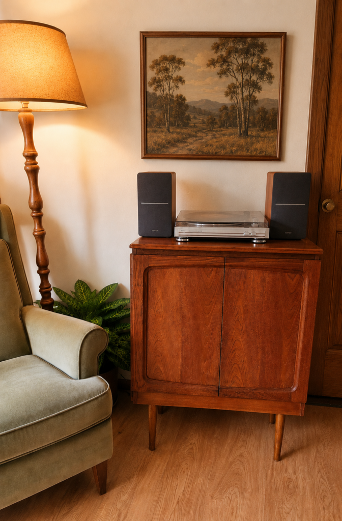 Image of a restored wooden cabinet with a record player, lamp, picture and velvet armchair