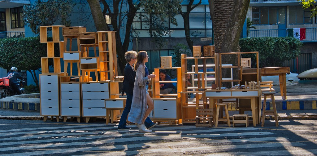 Two women walking past furniture out on the street being given away