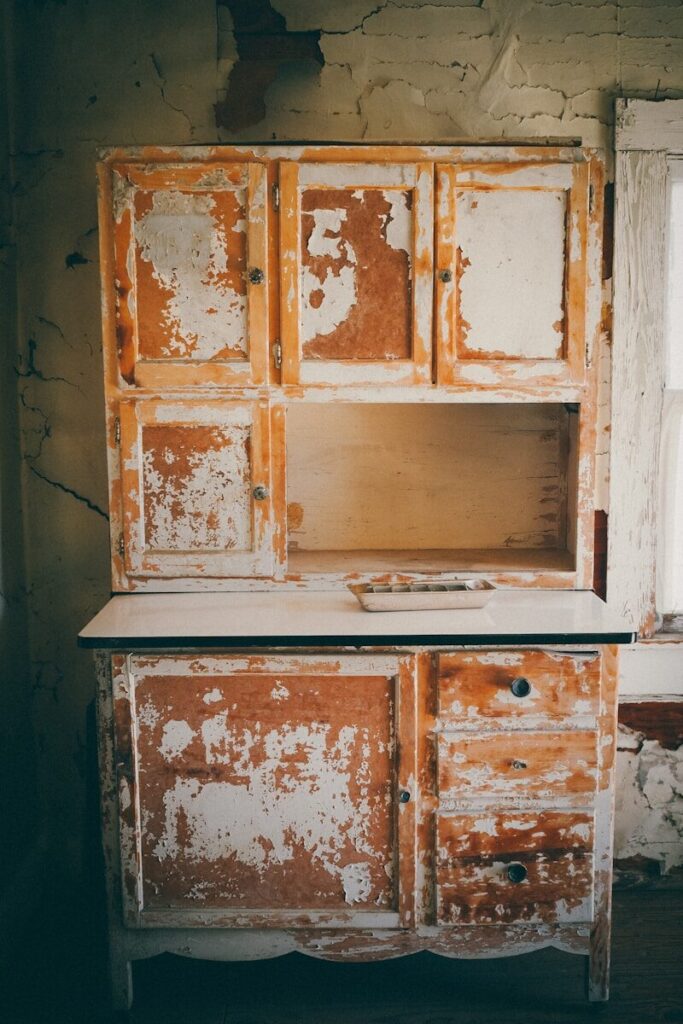 An old cabinet suitable for renovation or restoration with peeling paint, requiring sanding