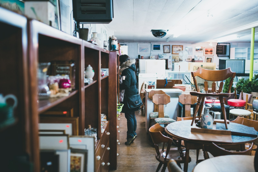 Thrift store/op shop/charity shop image of a person browsing for furniture and other second-hand items