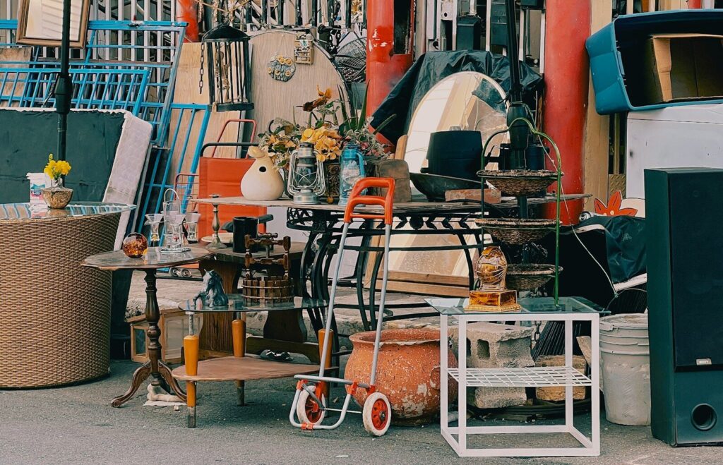 a pile of old furniture sitting on the side of a road at a garage sale