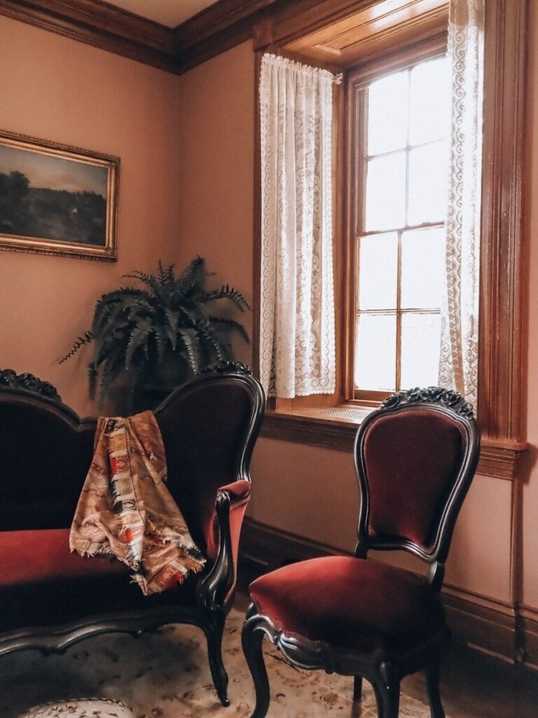Ornate red velvet sofa and chair in a vintage room.